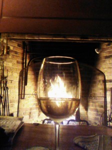 A glass of wine by the fire